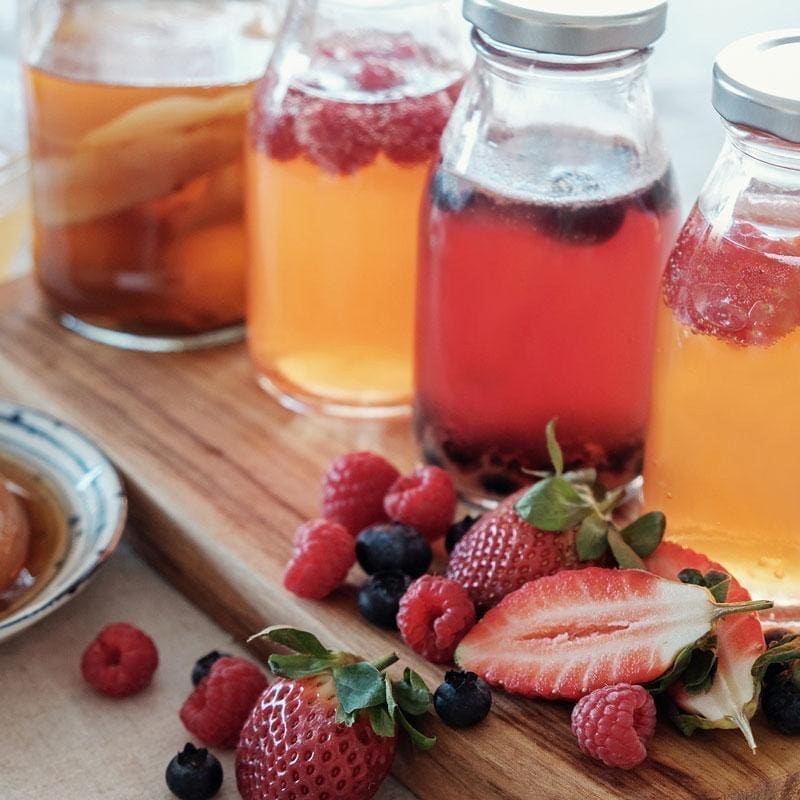 Kombucha tea in bottles with fruit pieces